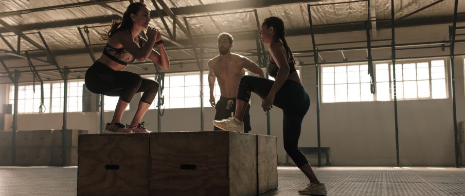 Mujeres y hombre realizando el ejercicio de Step-up para tonificar glúteos